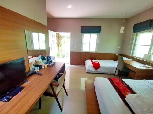 Takua Thung的住宿－Bangnu Greenery Resort，酒店客房设有一张桌子、一张床和一间卧室。