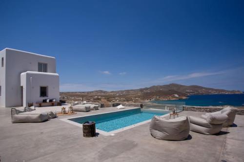 a pool with couches and chairs next to a building at Cabana Seaview Pool Villas w Night Security Guard, near Alemagou beach in Elia