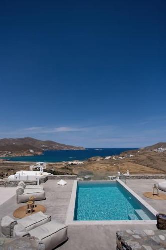 a swimming pool with chairs and a view of the ocean at Cabana Seaview Pool Villas w Night Security Guard, near Alemagou beach in Elia