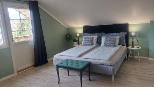 a bedroom with a large bed with a green wall at Øren apartment in Drammen