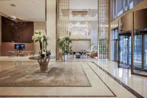 a lobby with a table and plants in a building at Concorde Tower Hotel & Casino in North Nicosia