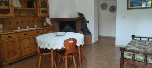una mesa y sillas en una cocina con chimenea en Casa Vacanza Alghero, en Santa Maria la Palma