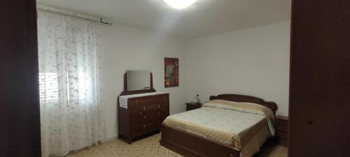 1 dormitorio con cama y vestidor con TV en Casa Vacanza Alghero, en Santa Maria la Palma
