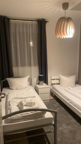 ザルシュテットにあるGold Star Apartment Nr.2のベッド2台とシャンデリアのある寝室