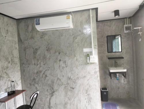 a bathroom with a stone wall with a sink at บ้านเล็กในป่าใหญ่ พัทลุง in Ban Nai Mon