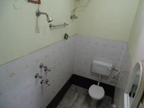 La petite salle de bains est pourvue de toilettes et d'un lavabo. dans l'établissement Hotel Teerth Guest House Inn Varanasi, à Varanasi
