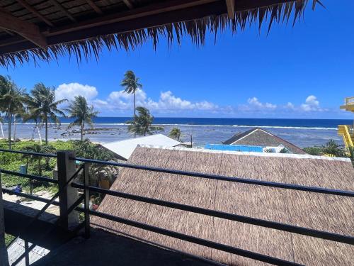 San IsidroにあるKatre Siargao - SELF CHECK-IN Hostelのビーチの景色を望むリゾートのバルコニーが備わります。