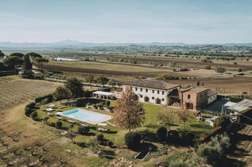 an aerial view of a house with a swimming pool in a field at Podere Il Belvedere su Cortona in Castiglion Fiorentino