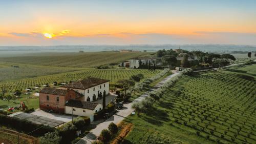 an aerial view of a village in a field with a sunset at Podere Il Belvedere su Cortona in Castiglion Fiorentino