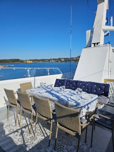 M/S Furusund في Furusund: طاولة وكراسي على قارب في الماء