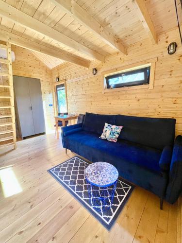a living room with a blue couch and a table at Projekt Przełazy in Przełazy