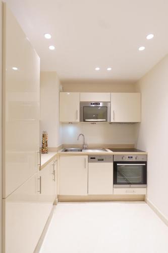 une cuisine avec des armoires blanches et un évier dans l'établissement Cannes: superbe appartement de type T2 pour 4 pers, à Cannes