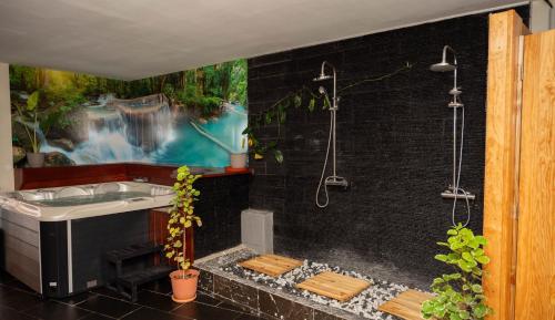 a bathroom with a shower and a sink and a bath tub at Jade hôtel and spa in Bandrélé
