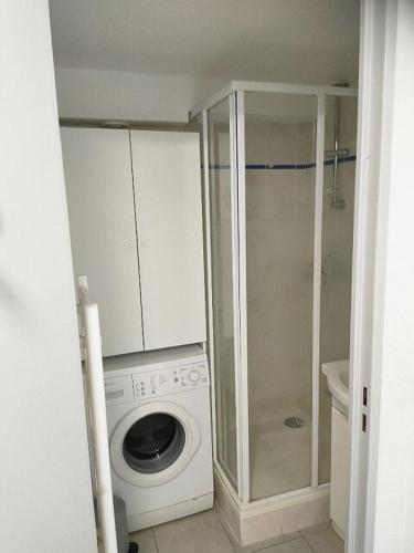 une machine à laver dans une salle de bain avec douche dans l'établissement Appartement Vue d'Or les pieds dans l'eau, à La Londe-les-Maures
