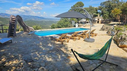 a pool with chairs and an umbrella and a slide at Finca Es Verger in Esporles