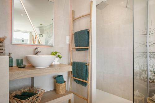 une salle de bain avec un lavabo et une douche dans l'établissement LIBERTY Héliopolis, au Cap d'Agde