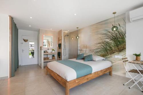 une chambre avec un grand lit dans une pièce dans l'établissement LIBERTY Héliopolis, au Cap d'Agde