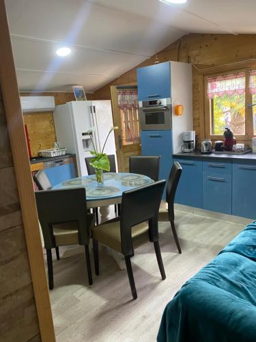 une cuisine et une salle à manger avec une table et des chaises dans l'établissement Grand chalet tout équipé 6 personnes proche des plages du débarquement, à Sommervieu