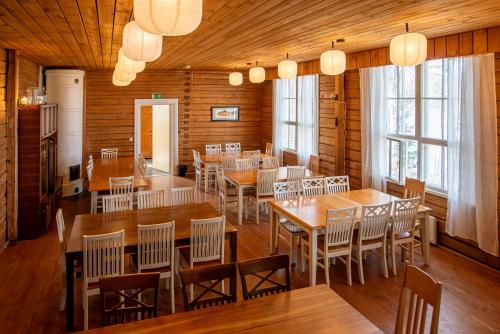 a dining room with wooden floors and tables and chairs at Ahoniemi - Kellankoski in Rossi