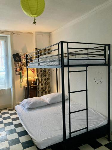 une chambre avec un lit superposé avec des draps blancs dans l'établissement Maison sympa en centre-bourg, à Montebourg