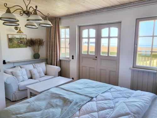 a bedroom with a bed and a couch and windows at Beach house Tolsburg with sauna in Toolse