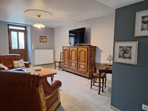 un salon avec un canapé et une télévision dans l'établissement Maison De Vacances, à Blondefontaine