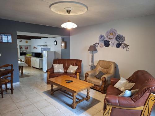 a living room with leather chairs and a table at Maison De Vacances in Blondefontaine