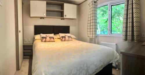 a bedroom with a large bed with two animals on it at Forest View at Oakdene Forest Park in Ringwood
