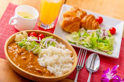 Hotel Pasela Living في طوكيو: طاولة مع وعاء من الأرز وصحن من الطعام