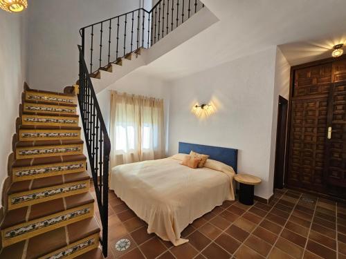a bedroom with a bed and a spiral staircase at Finca Altair in Madrid