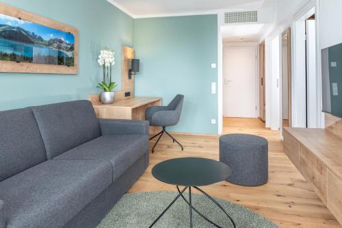 a living room with a couch and a table at AllgäuStern Hotel in Sonthofen