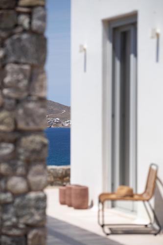 a chair sitting on a porch looking out at the ocean at Cabana Seaview Pool Villas w Night Security Guard, near Alemagou beach in Elia