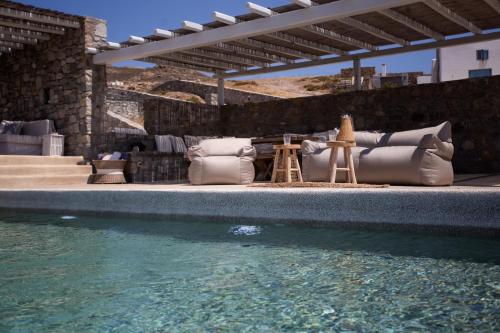 a swimming pool with pillows and a table and water at Cabana Seaview Pool Villas w Night Security Guard, near Alemagou beach in Elia