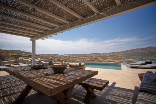 a wooden table on the patio of a house at Cabana Seaview Pool Villas w Night Security Guard, near Alemagou beach in Elia
