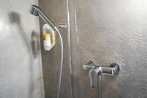 eine Dusche mit Duschkopf an der Wand in der Unterkunft Hotel Schiffahrt in Mols