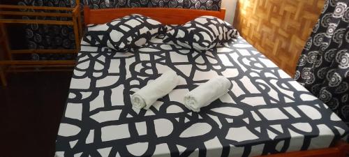 łóżko z czarno-białą kołdrą i 2 rolkami papieru toaletowego w obiekcie EESTEE Canal w Kolombo
