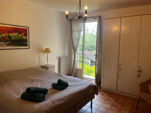 um quarto com uma cama com duas toalhas verdes em Le Mas de Trévouse em Saint-Saturnin-lès-Avignon