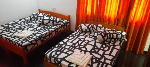 dwa łóżka siedzące obok siebie w pokoju w obiekcie EESTEE Canal w Kolombo