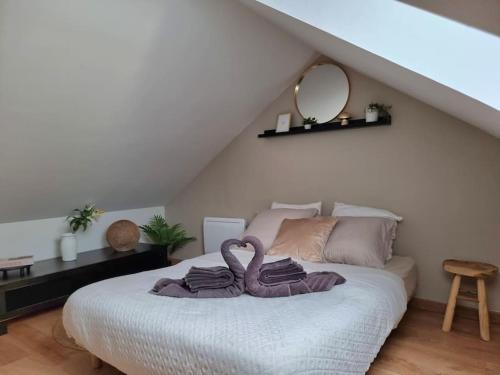 ein Schlafzimmer mit einem Bett mit zwei Schwänen darauf in der Unterkunft Maison aux portes de Tours in Saint-Pierre-des-Corps