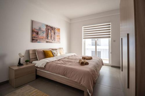 Un dormitorio con una cama con un osito de peluche encima. en LA88 Cityway Apartment 4, en Il-Gżira