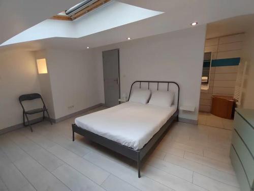 Un dormitorio con una cama y una silla dentro. en Le triplex de l'union, en Périgueux