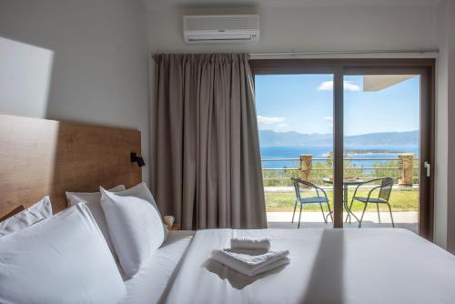 1 dormitorio con 1 cama y vistas al océano en Sunlight Elounda - Adults only Hotel "by Checkin", en Agios Nikolaos