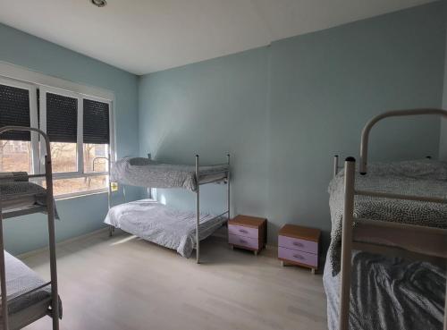 a room with three bunk beds and a window at Albergue de Guardo in Guardo