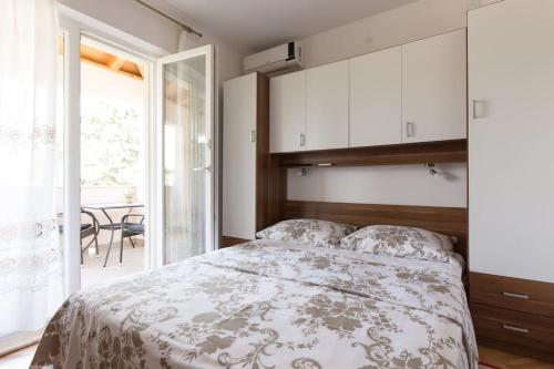a bedroom with a bed and a large window at Studio Ruzmarin in Krk