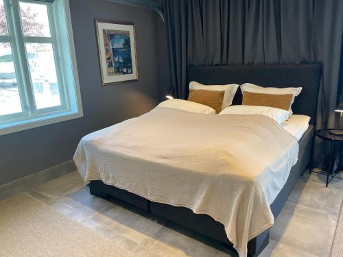 a bedroom with a large bed with white sheets and pillows at Suite i gjestehus, nær sentrum in Sandefjord