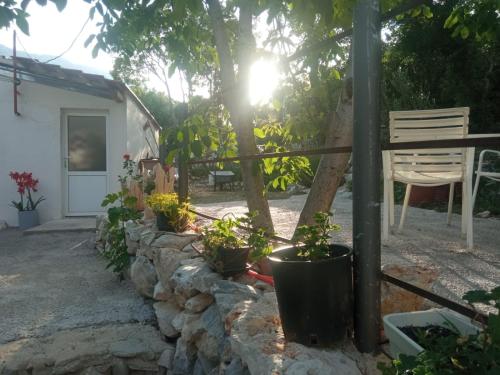 a garden with a stone wall and a bench and a tree at Studio Biokovo smaller object 22 m2 in Makarska