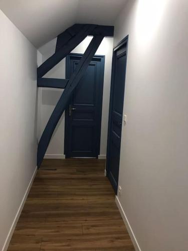 a hallway with two blue doors and a wooden floor at la maison d'en bas avec belle piscine in Chailley
