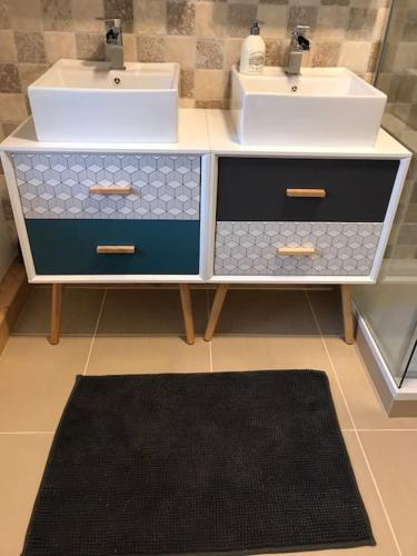 a bathroom with two sinks and a counter with a rug at la maison d'en bas avec belle piscine in Chailley