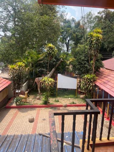 a view of a garden from a balcony at Hotel Madhura in Belgaum