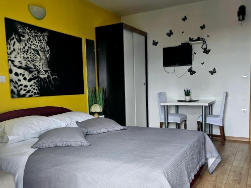 een slaapkamer met een bed, een tafel en een televisie bij Apartments Casablanca in Podstrana